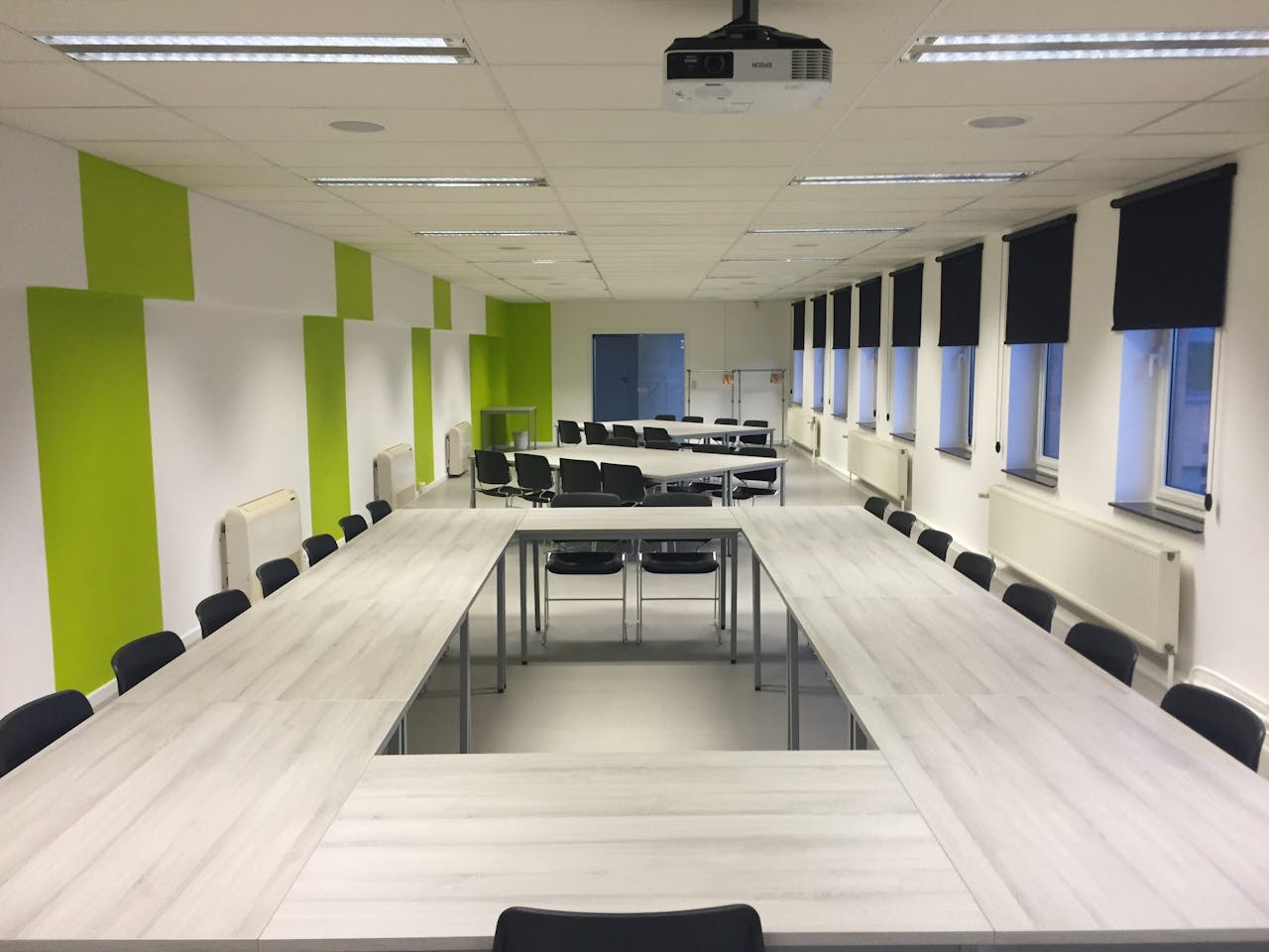 À propos de nous Spacious indoor meeting room with modern furniture and large windows.